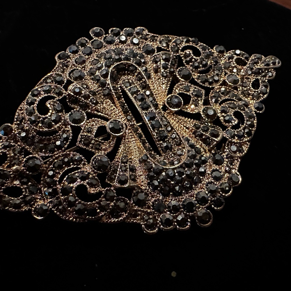 Hematite and gold tone brooch
